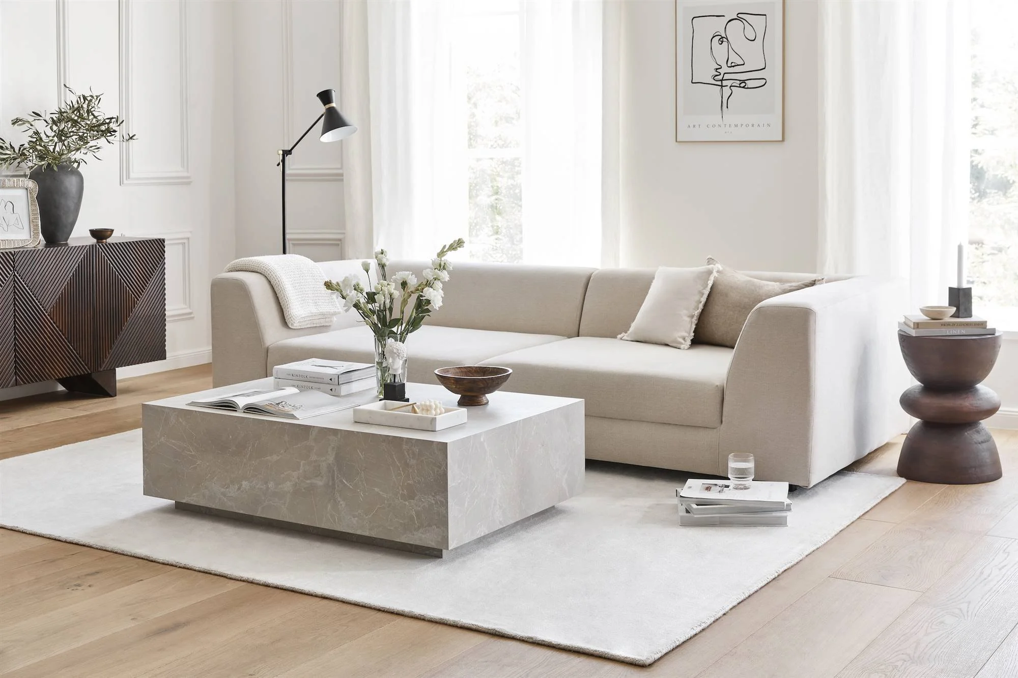 Salón reformado con sofá beige y mesa de piedra